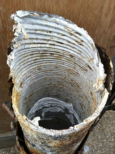 This is an extreme case of the corrosion caused when sulphuric acid is formed by burning smokeless fuels. If left unchecked the flue/liner will fail (as in this case) and allow the acids to attack the inside of the chimney making it structurally unsafe